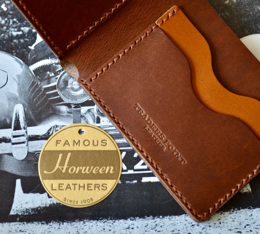 Open bifold wallet in Horween leather beside a brass Famous Horween Leathers tag